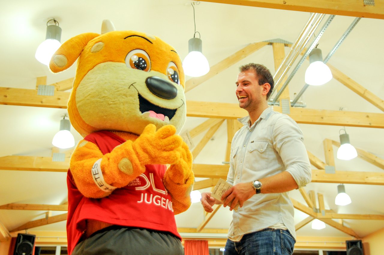 Maskottchen im Gespräch mit einem lachenden Gast
