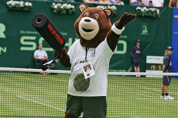 Bären-Maskottchen begrüßt das Publikum bei einem Tennis-Event